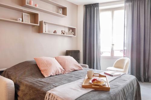- une chambre avec un lit et un plateau de nourriture dans l'établissement Le Gourmet du Marais, à Paris