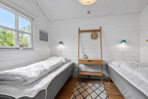 two beds in a room with white walls and a window at LN1926-Hjorring-Jollevej-2 in Hjørring