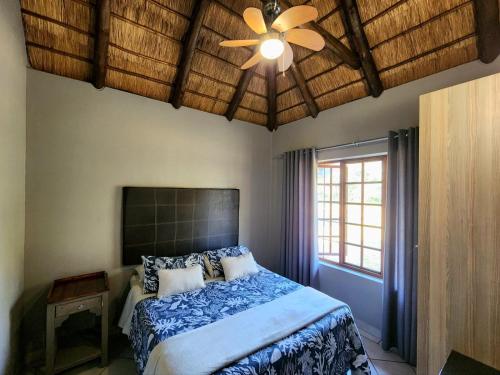 a bedroom with a bed and a ceiling fan at Buyskop Lodge, Conference & Spa in Bela-Bela