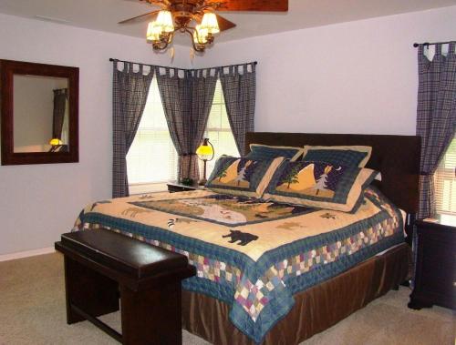 Schlafzimmer mit einem Bett mit einem Tisch und Fenstern in der Unterkunft Climbing Bear Creekside Cabin in Whittier