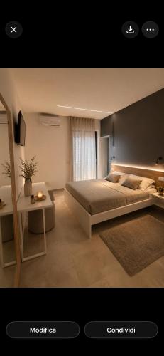 a bedroom with a large bed and a table at Altea in Taurianova