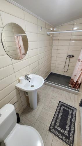 a bathroom with a toilet and a sink and a shower at Happy Time in Sredneye Vodyanoye