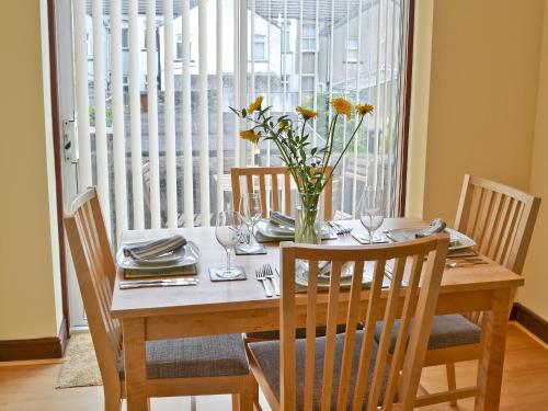 a dining room table with a vase of flowers on it at Combe Cairn in Millom
