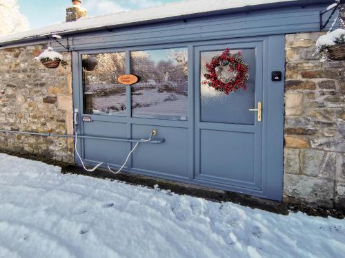 a blue garage door with a wreath on it at Acre Hill Cottage in Harrop Fold