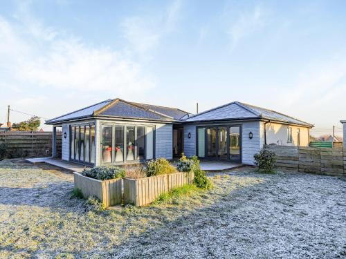 a house with a fence in front of it at Marram Dune Beach House in Brean