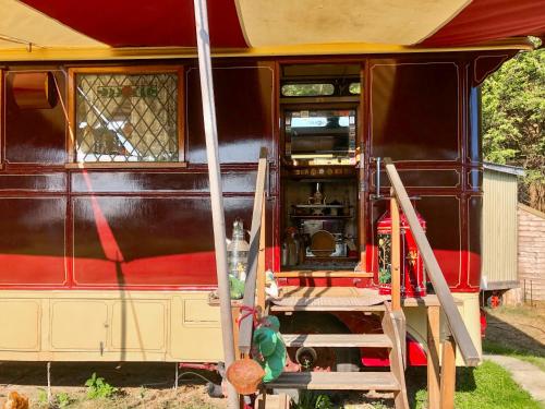 a red and black train car with the door open at Romney Wagon in Hailsham