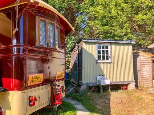 a red bus parked next to a small house at Romney Wagon in Hailsham