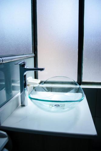 a glass sink in a bathroom with a faucet at Esmeralda con altura in Callampaya