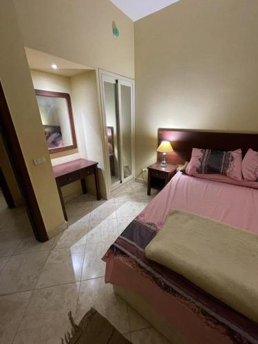 a bedroom with a bed and a table and a mirror at El wadi Pearl Residence in Ain Sokhna