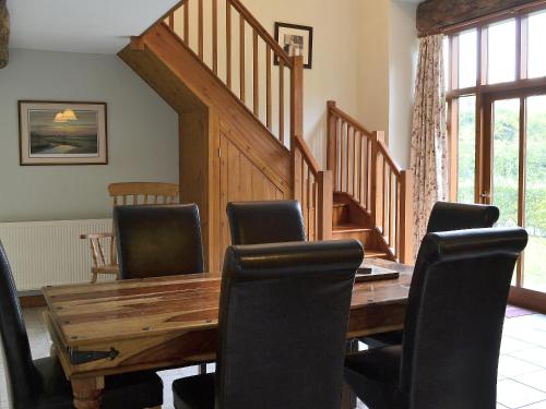 a dining room with a wooden table and chairs at Chive - E4326 in Catfield