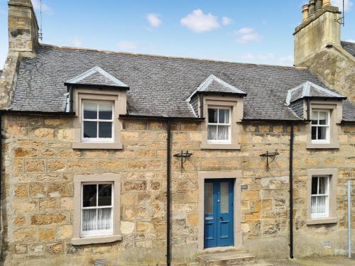 an old stone house with a blue door at Solus Na Madainn in Tain