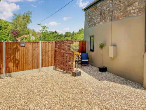 a backyard with a fence and a brick wall at The Old Posthouse Barn - Uk50191 in Weare