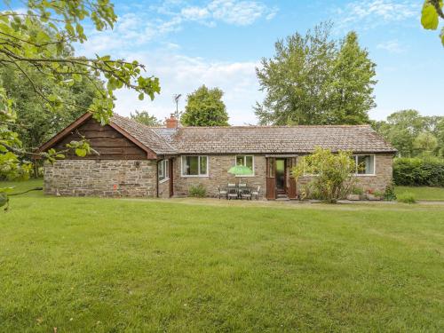 a stone house with a lawn in front of it at Steep Holm in Kington
