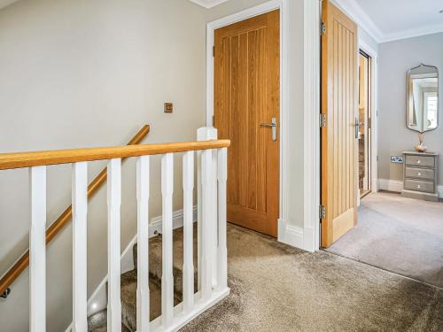 a hallway with stairs and a wooden door at Ridings Cottage in Helmsley