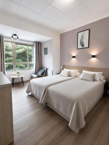 a hotel room with a large bed and a chair at Casa Durán Alicante in Alicante