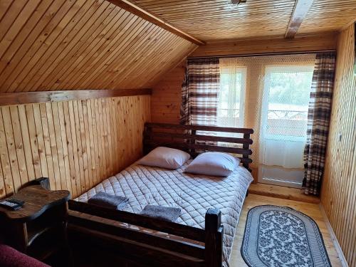 a bedroom with a bed in a wooden cabin at Садиба Сузір'я in Vorokhta