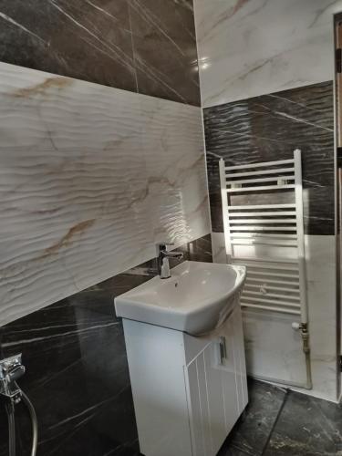 a bathroom with a white sink and a chair at Вила Мариам Villa Mariam in Batak