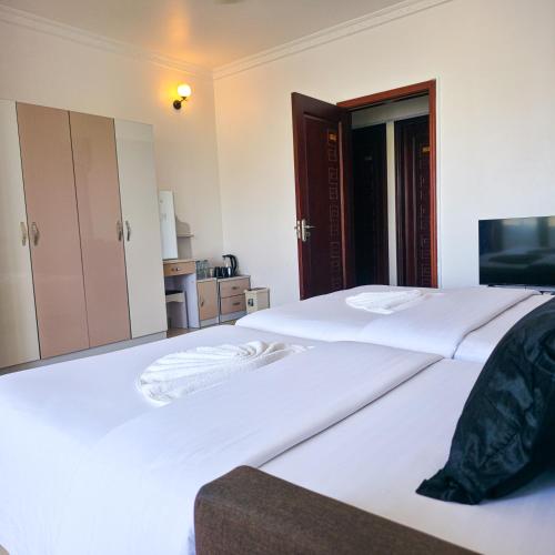 two beds in a room with two white beds at Reef Guest House in Male City