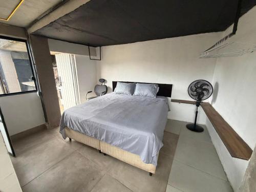 a bedroom with a bed and a fan in it at Mirante de itaipava in Itaipava