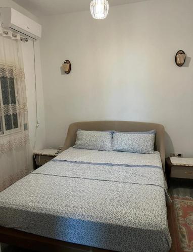 a bed in a white room with two pillows on it at Maison pieds dans l'eau in Chebba