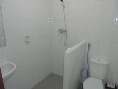 a bathroom with a shower and a toilet and a sink at Pondok Salacca#bamboohouse# in Candidasa