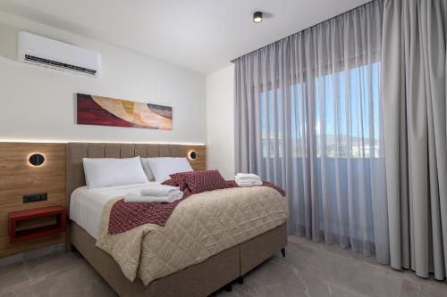 a bedroom with a bed and a large window at Costa Blu Mare in Haraki