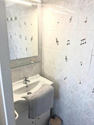 a white bathroom with a sink and a mirror at STUDIO 100 m PLAGE in Le Portel