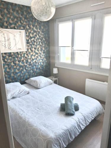 a bedroom with a bed with a stuffed animal on it at STUDIO 100 m PLAGE in Le Portel