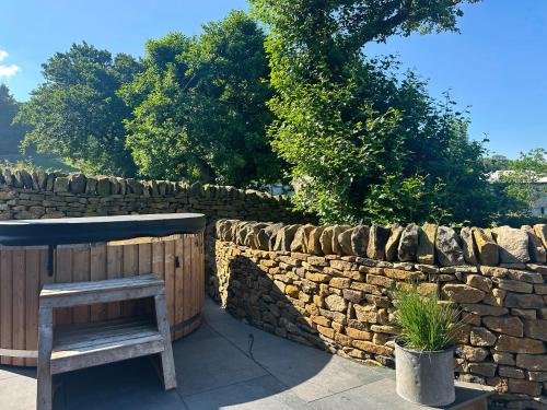 a bench sitting next to a stone wall at Moorgate Lodge - Uk47742 in Kelbrook