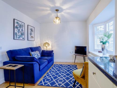 a living room with a blue couch and a tv at Vineyard's Apartment - Uk36748 in Ely