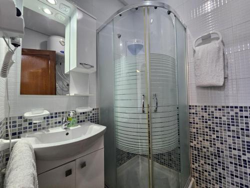 a bathroom with a glass shower and a sink at Cabo Alegre in Martil