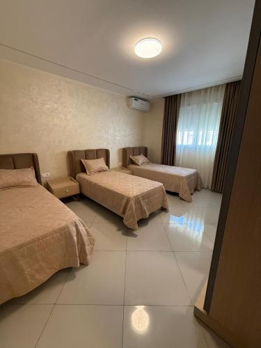 a hotel room with two beds in a room at إقامة الرمال الذهبية in Les Hamiane
