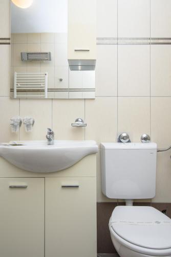 a white bathroom with a toilet and a sink at Hotel B&B Villa Paula in Trogir
