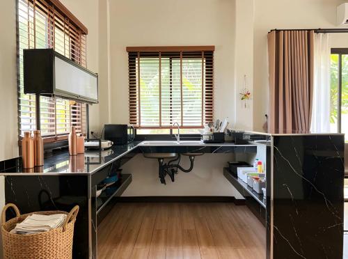 a kitchen with a desk with a sink in it at Thara Bohemia Villa in Hinkong