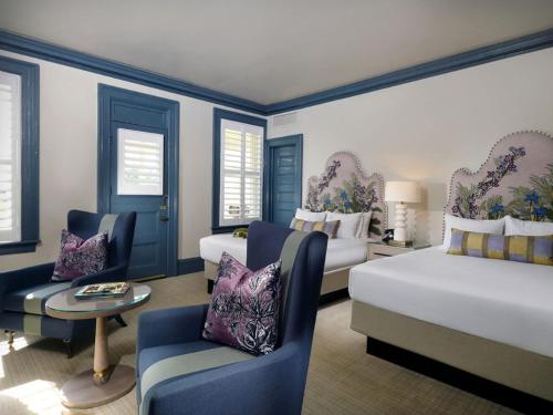 a bedroom with two beds and a couch and a chair at Jekyll Island Club Resort in Jekyll Island