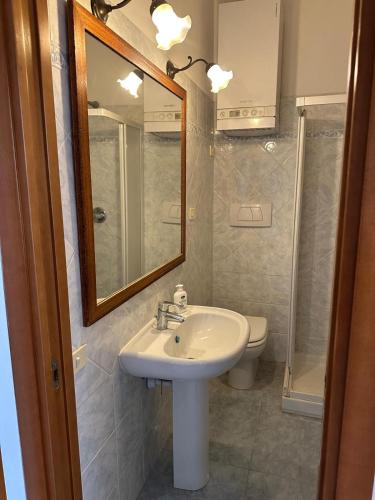 a bathroom with a sink and a mirror and a toilet at Casa FERRIGNO in Portoferraio