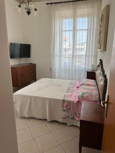 a bedroom with a bed and a television and a window at Casa FERRIGNO in Portoferraio