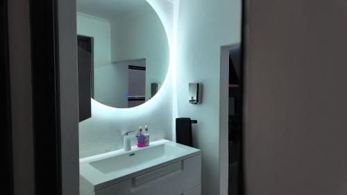 a bathroom with a white sink and a mirror at Lora Gardens in Chartwell