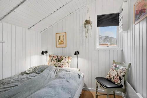 a bedroom with a bed and a chair and a window at sj278-Bjert-Binderup-Strandpark-80 in Åbjerg