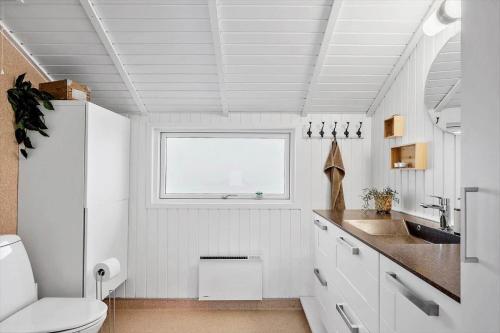 a bathroom with a toilet and a sink and a window at sj278-Bjert-Binderup-Strandpark-80 in Åbjerg