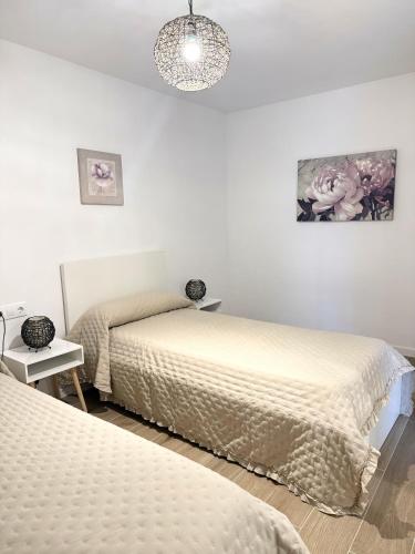 a bedroom with two beds and a chandelier at Casa Silvestre in Puigmoreno