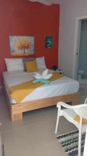 a bedroom with a large bed with a red wall at Hogar flores in La Ceiba