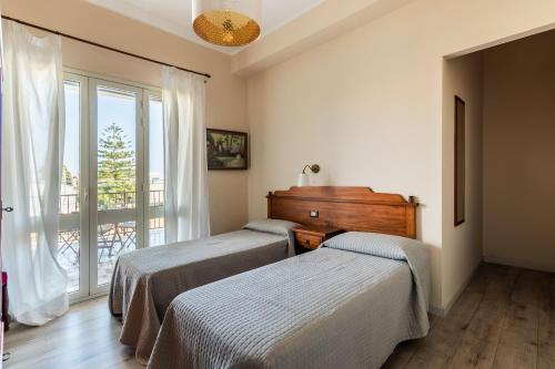 two beds in a room with a window at B&B La terrazza sul mare in Avola