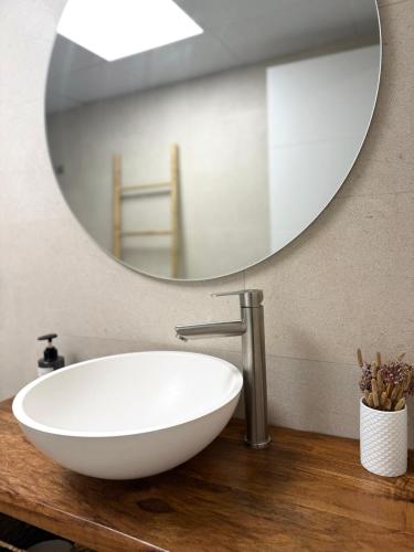 a bathroom with a white sink and a mirror at Casa Silvestre in Puigmoreno