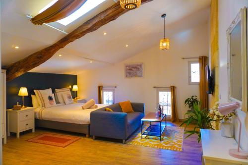 a bedroom with a bed and a chair in a room at Hôtes de Saint-Emilion II in Saint-Émilion
