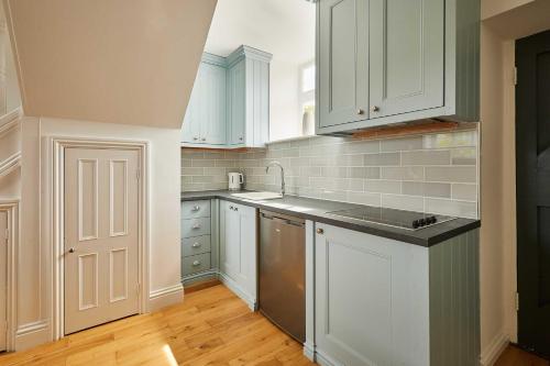 a kitchen with white cabinets and stainless steel appliances at Host & Stay - The Spinney in Consett