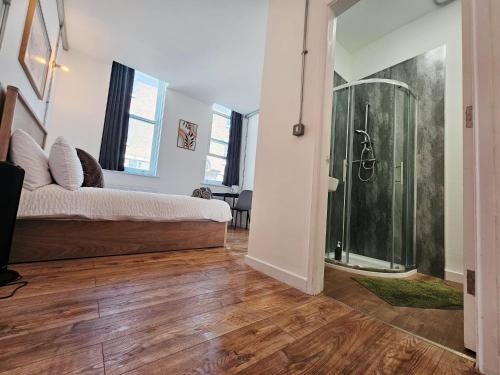 ein Schlafzimmer mit Dusche und Bett in einem Zimmer in der Unterkunft The Nest Lite in Sheffield