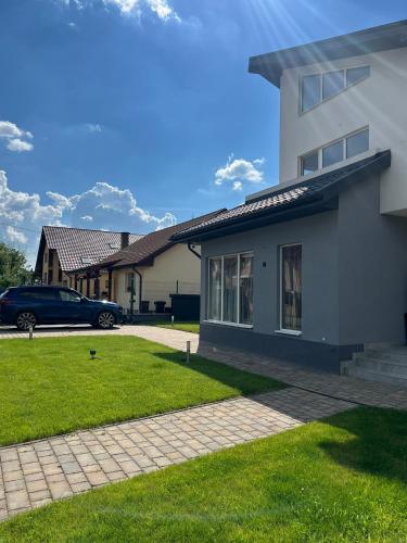 a house with a car parked in the driveway at StGeorge Retreat in Sângeorgiu de Mureș