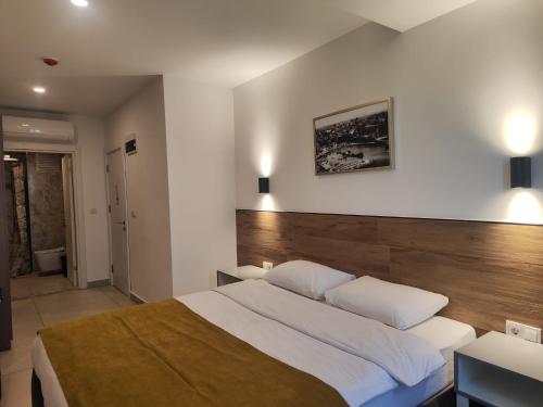 a bedroom with a large bed with a wooden headboard at Tut Hotel in Antalya