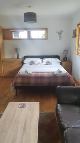 a bedroom with a bed and a couch at Loch Ness Studio Blairbeg in Drumnadrochit